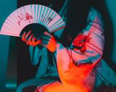 一名身着传统和服的女子手持扇子，在鲜艳的红蓝灯光映照下