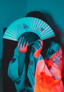 一个身着传统服装的人手持彩扇，散发着神秘感
