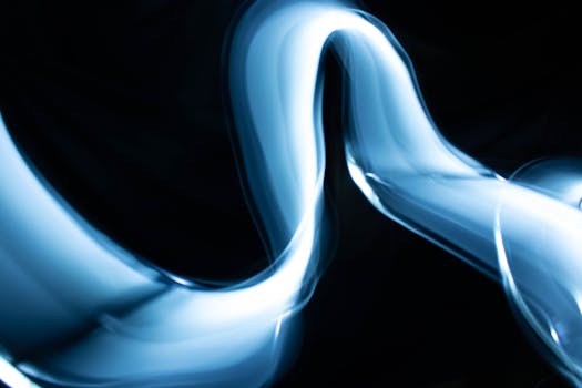 Dynamic abstract image of blue light streaks against a dark backdrop, perfect for modern designs.