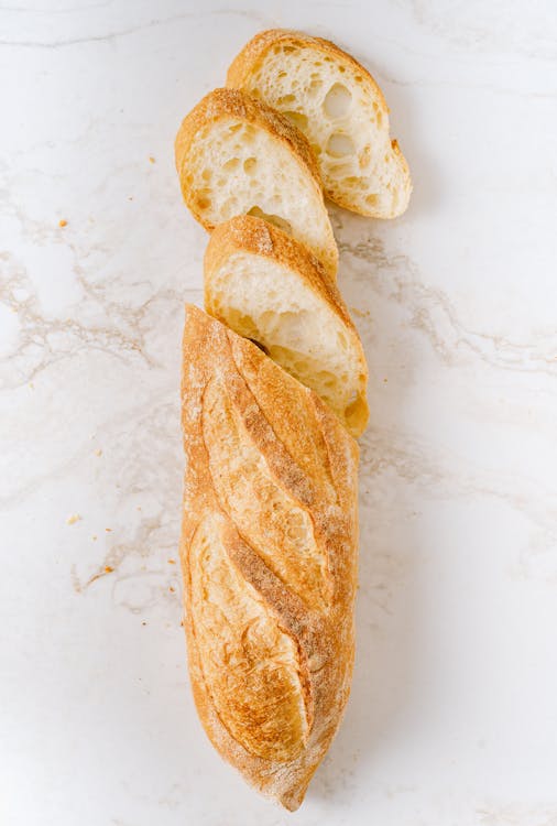 Free Tasty Baguette on White Marble Surface Stock Photo