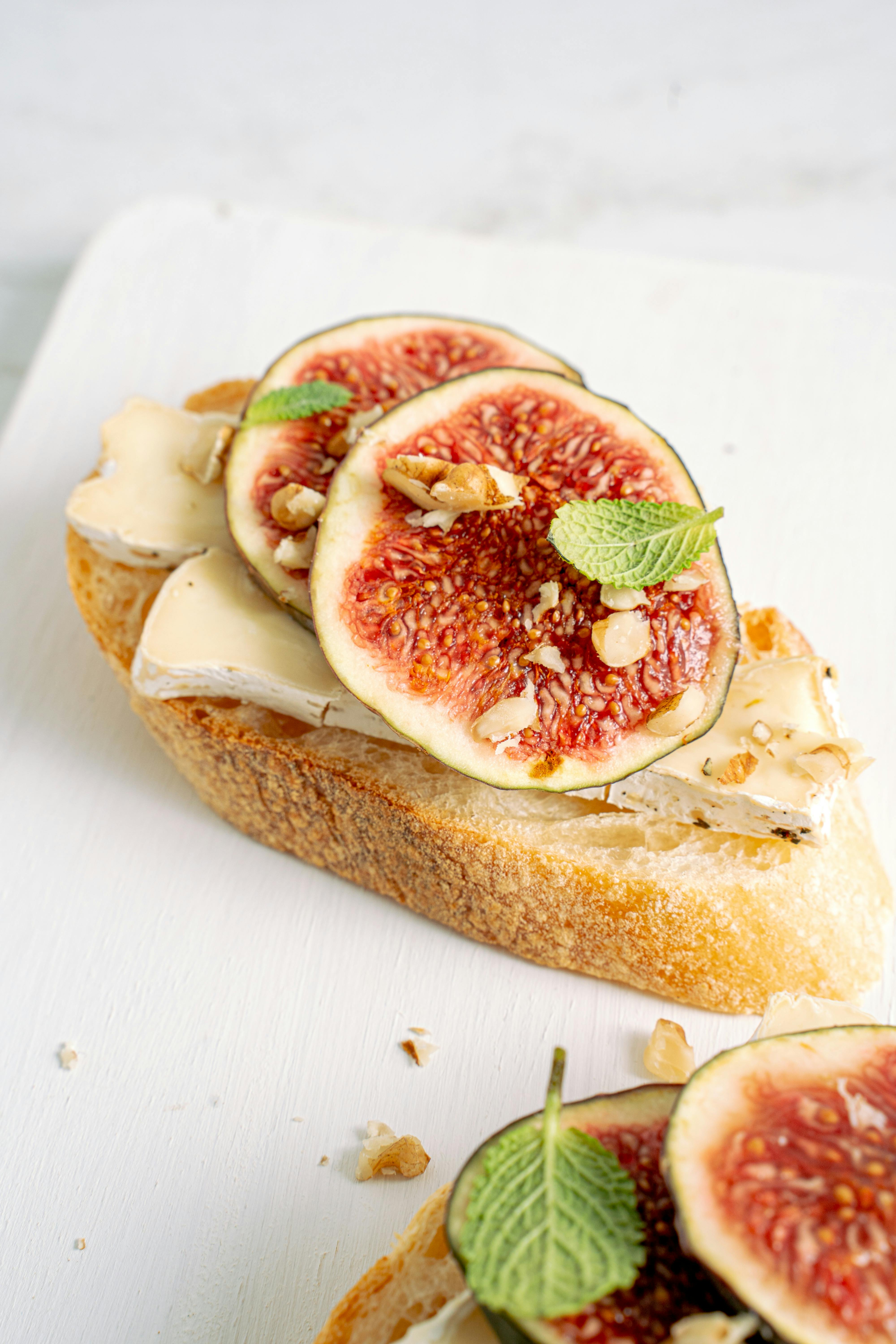 bread with sliced tomato on white textile