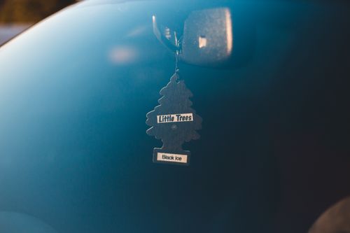 Free Through glass of tree shaped air freshener hanging from mirror in car in sunlight Stock Photo
