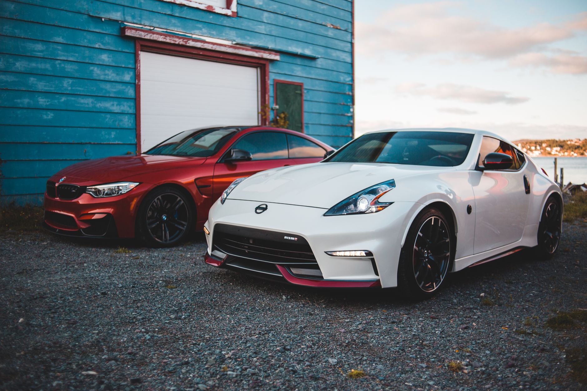Stylish shiny tuned red and white sports cars parked near rustic barn at lakeside in suburb area — free online jigsaw puzzle on JigsawPuzzlesFreeOnline.org