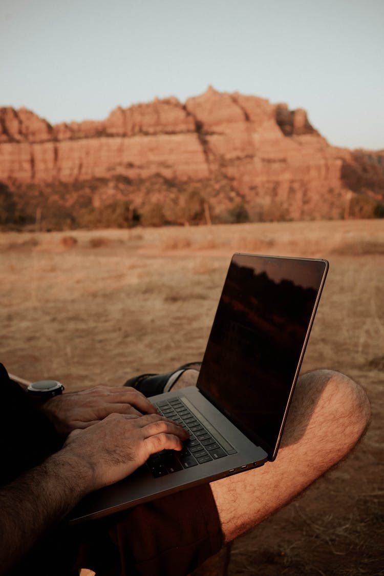 Crop Man Working On Laptop In Countryside