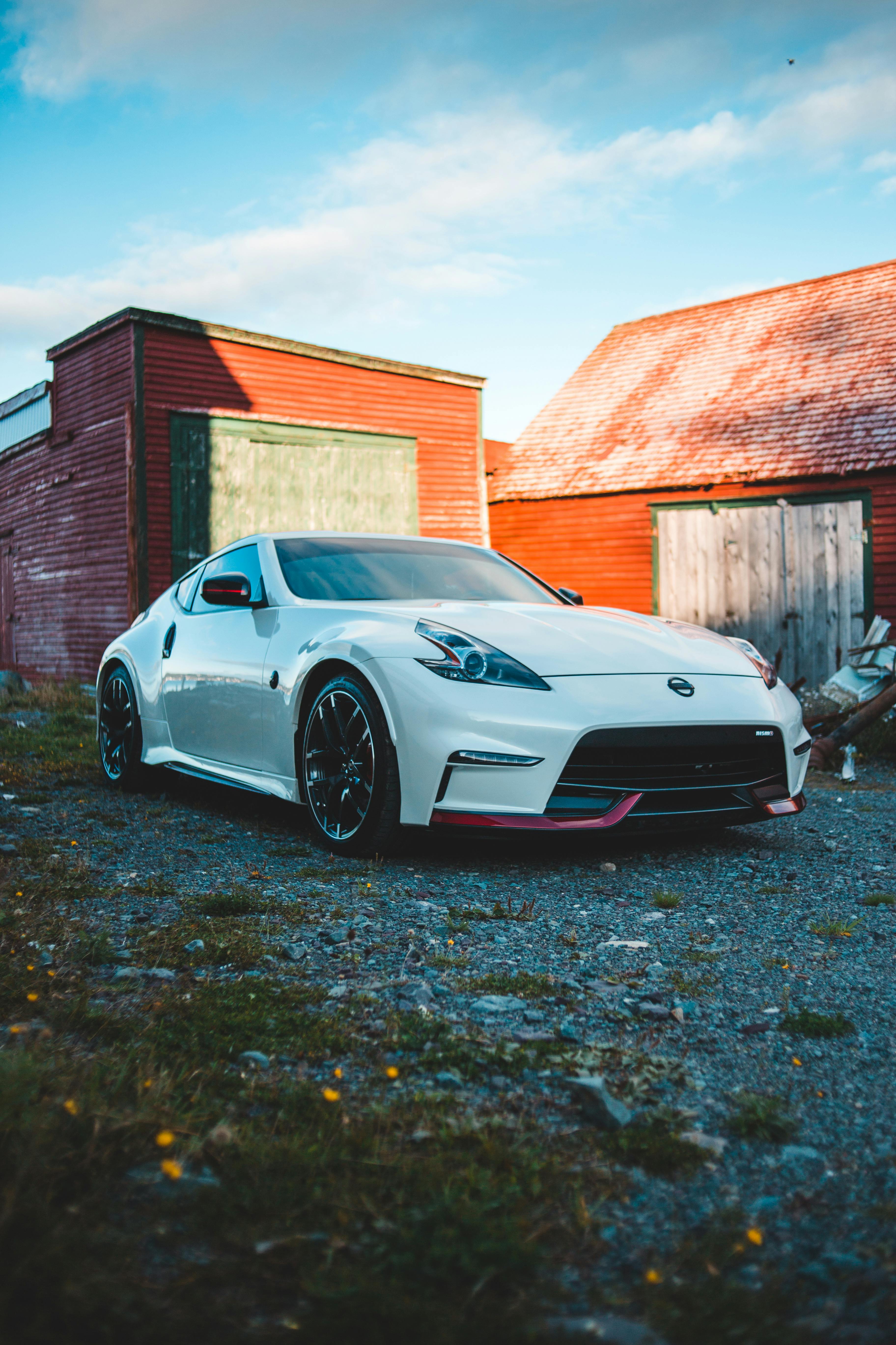 expensive white car near brick garage