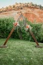 Brown Wooden Swing on Green Grass Field