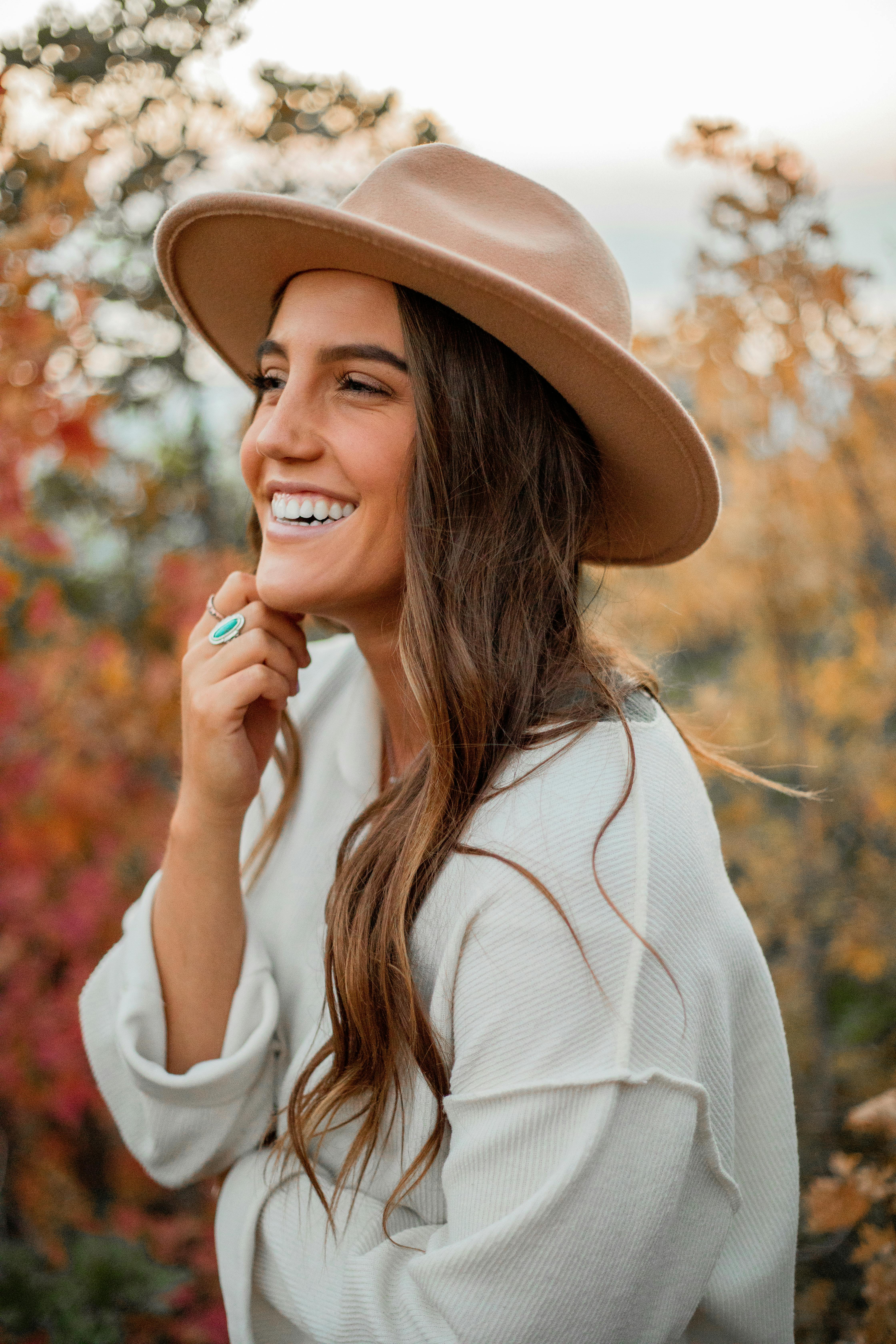 Smiling Woman Wearing Brown Hat and White Long Sleeve Shirt · Free Stock  Photo