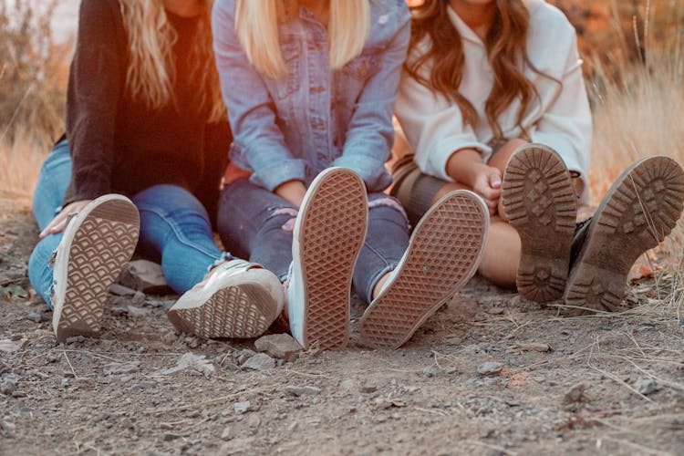 Feet Of Girls Sitting On Ground