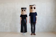 一对夫妇在现代环境中戴着独特的手工纸板面具作为万圣节服装