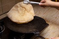 A homemade chapati being cooked on a stove, showcasing traditional Indian bread preparation.