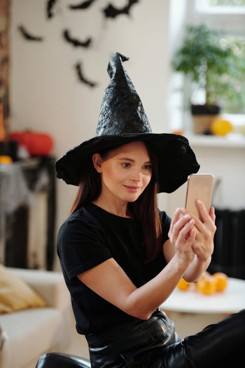 Donna In Camicia Nera E Cappello Da Strega Nero Mentre Si Fa Un Selfie ·  Immagine gratuita