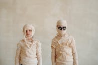 两个穿着木乃伊服装的孩子摆好姿势拍摄万圣节照片