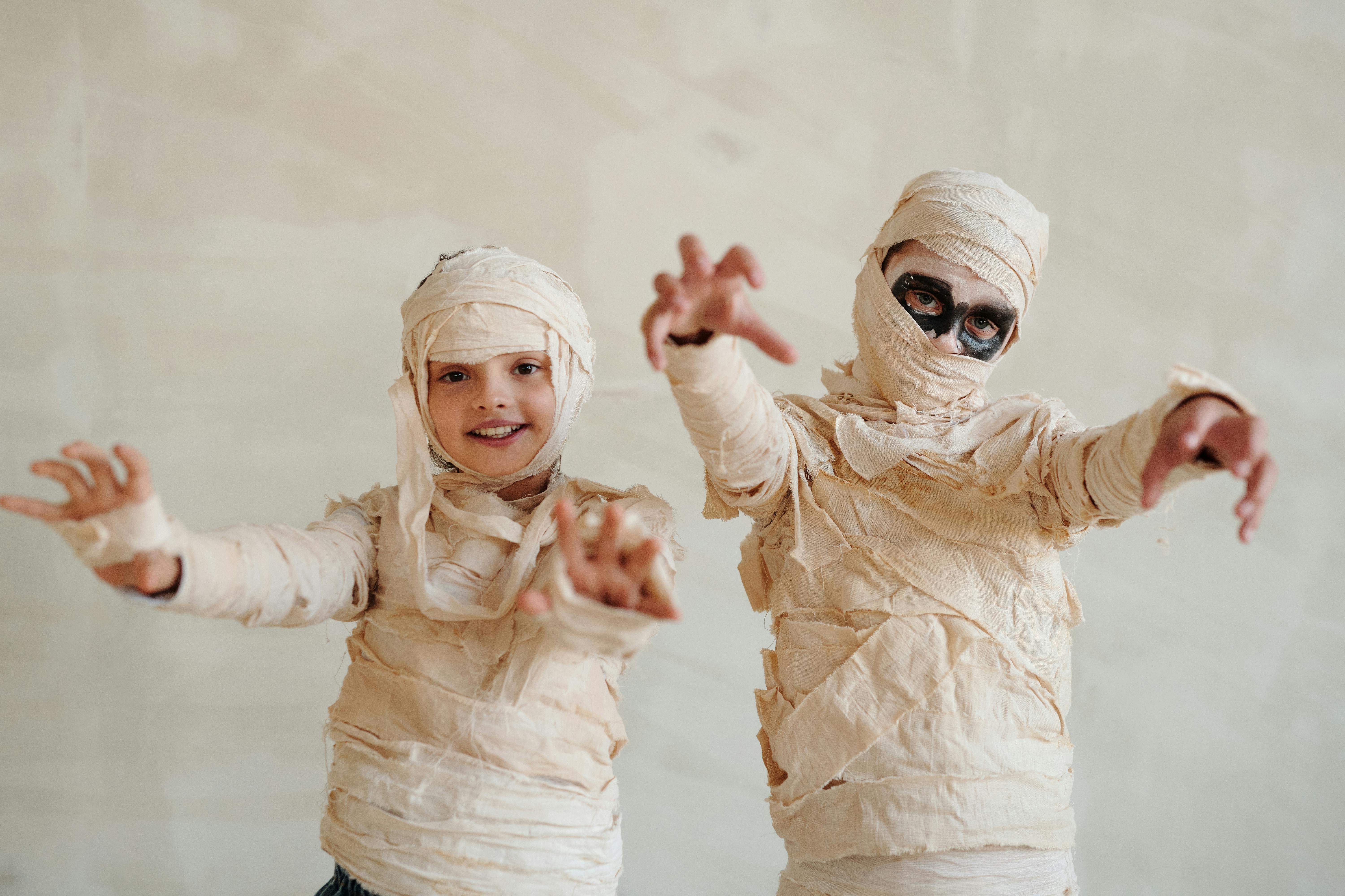 two kids wearing a mummy costume