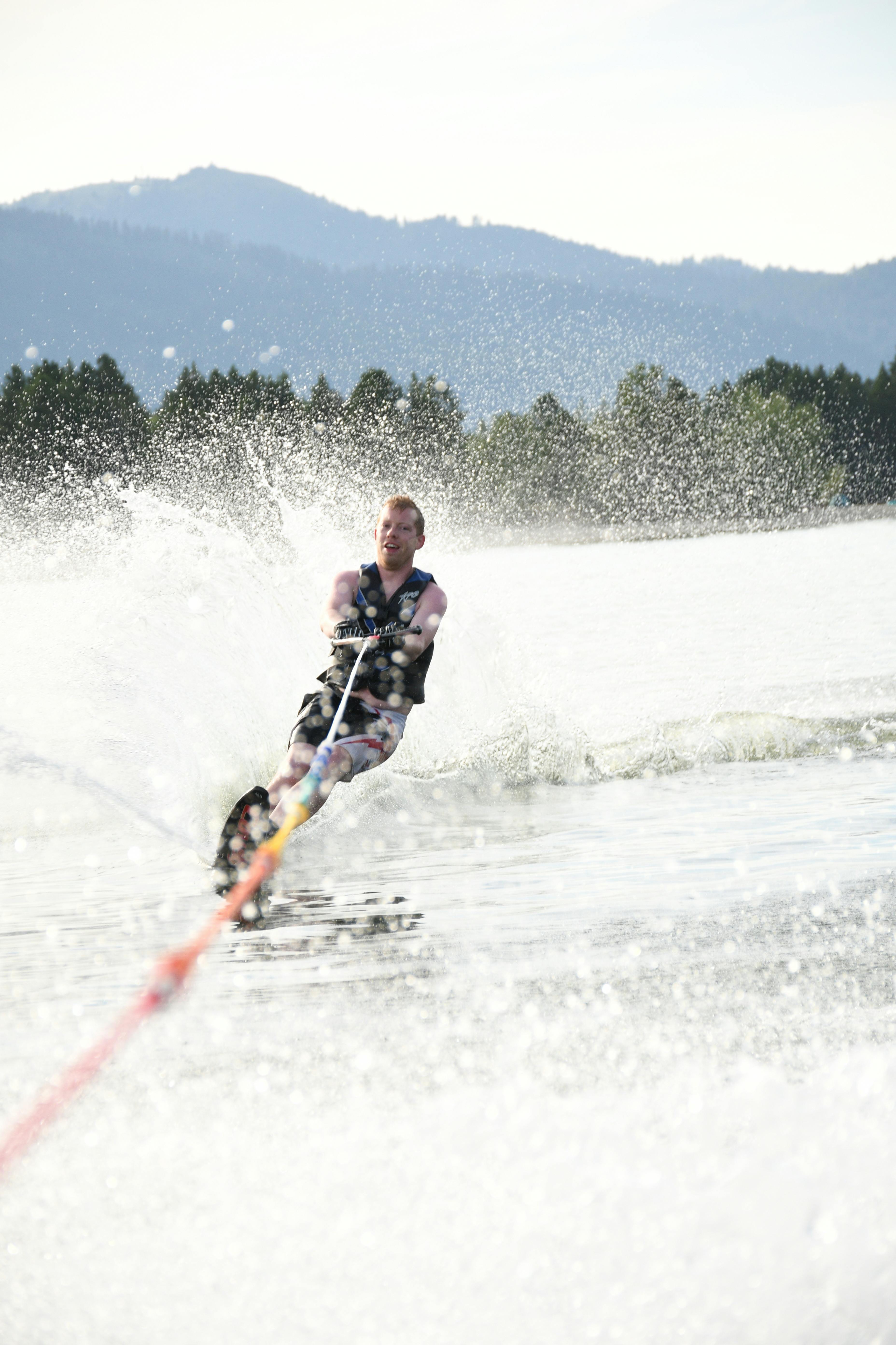 Excited sportsman practicing water skiing on splashing ocean · Free