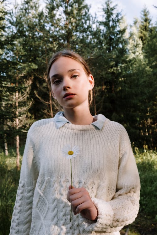 A Woman Holding a Chamomile Flower