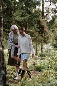Elderly woman and young girl walking through lush green forest, sharing a peaceful moment.