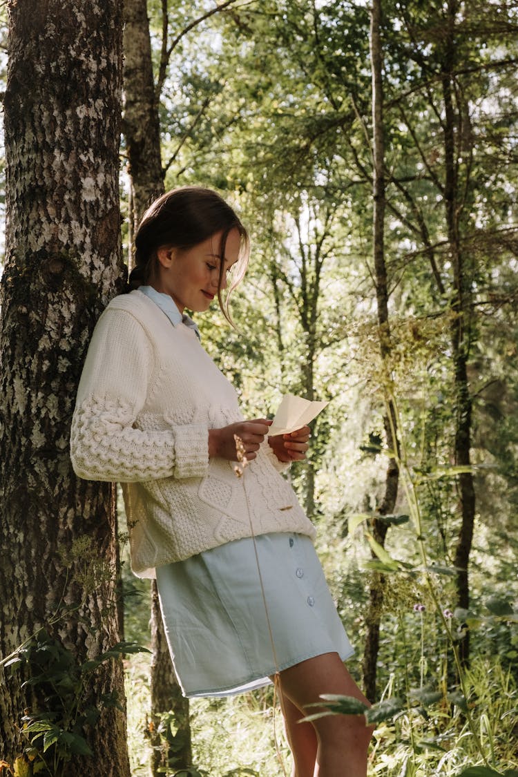 A Woman Reading A Letter In The Woods