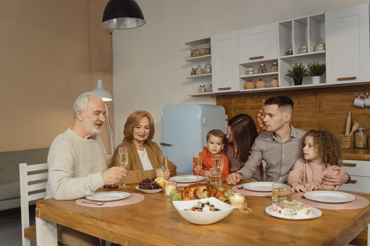 Multi-generational family sharing a meal together around a kitchen table