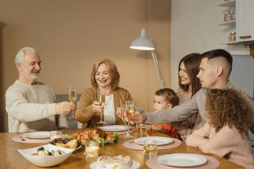 Free A joyful family toasts together over a festive dinner with champagne indoors. Stock Photo