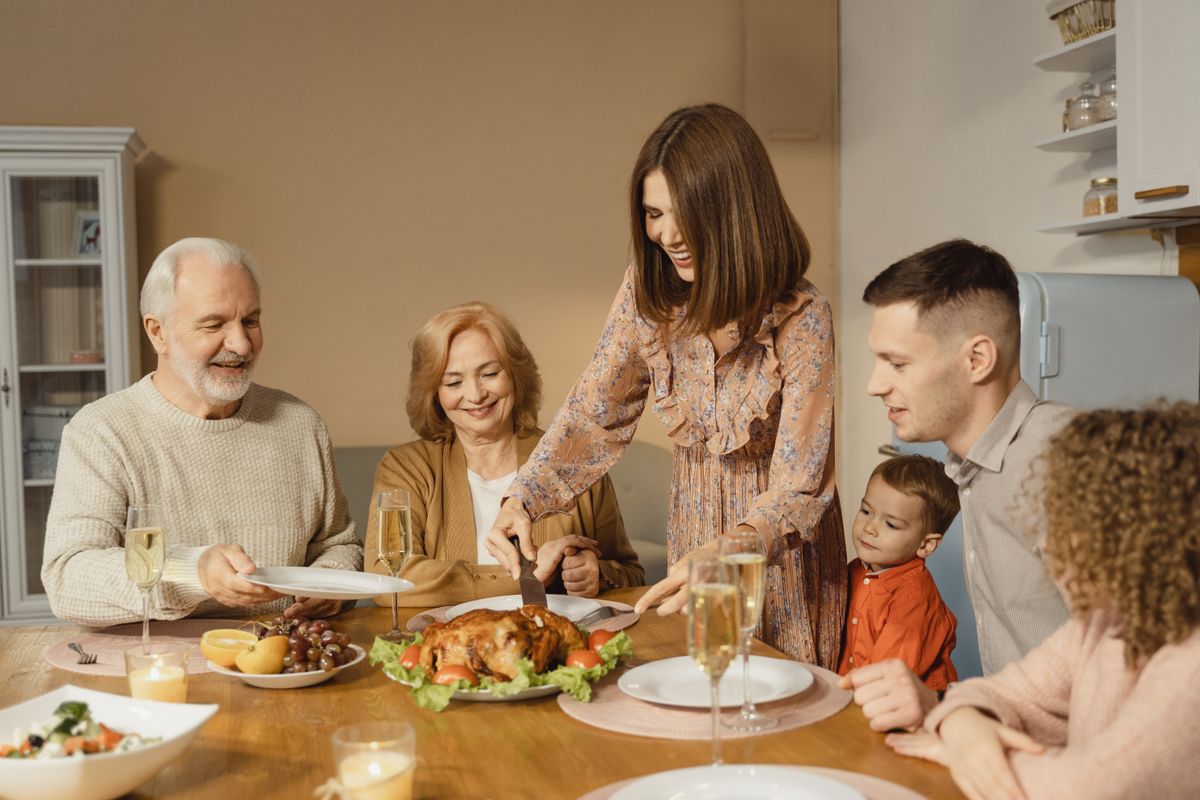 Joyful multi-generational family gathered around the dining table for Sunday dinner