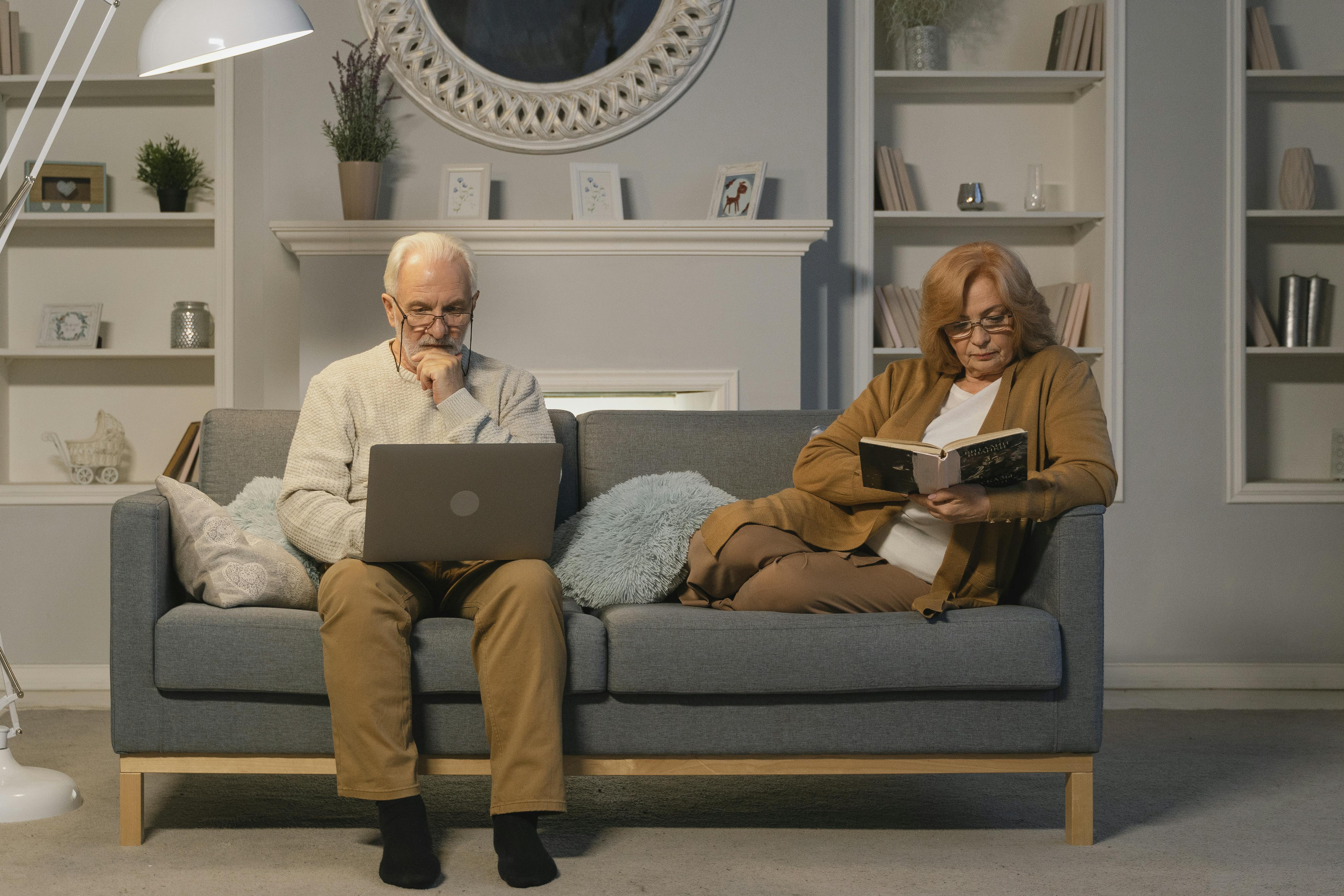 a man sitting on couch using a laptop