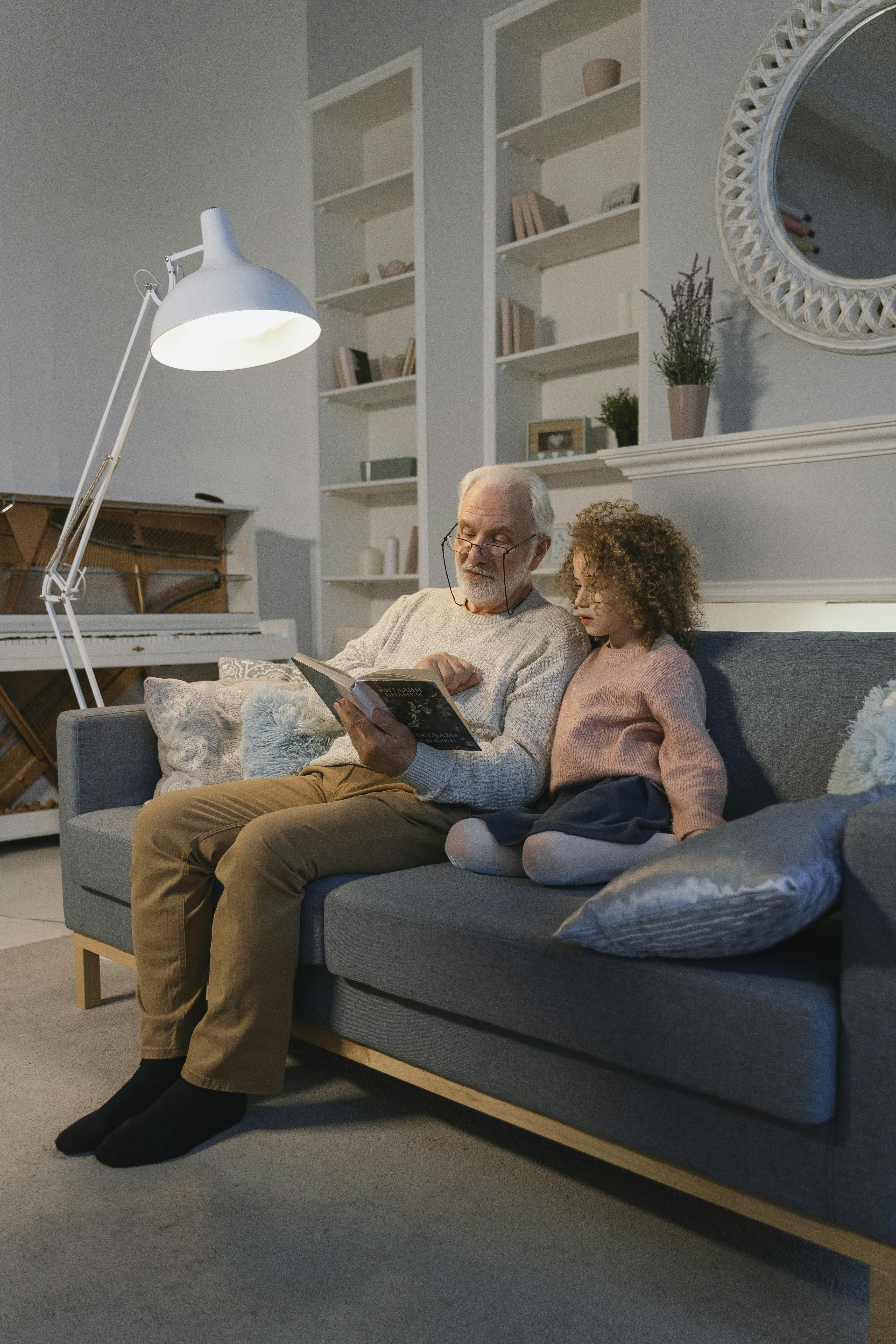 a man reading a book together with a young girl