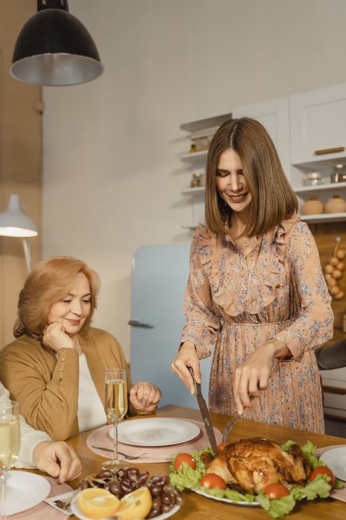 Free A joyful family dinner with a turkey and champagne, symbolizing warmth and togetherness. Stock Photo