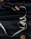 Reels of thread and measuring tape with wicker ball placed on dark cloth