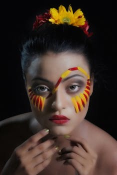 A striking portrait featuring colorful artistic makeup and floral accessories.