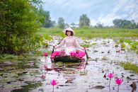 Woman in Pink Dress Sitting on Water With Pink Lotus Flowers