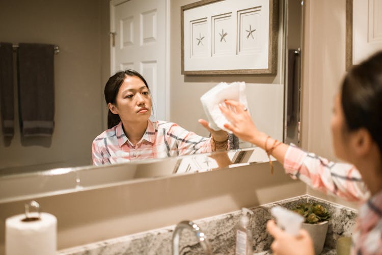 Woman Wiping The Mirror