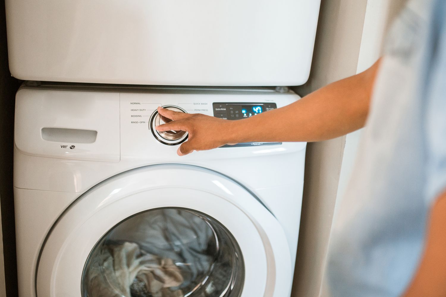 Person checking a modern washing machine control panel