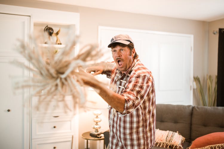 Man In Checkered Shirt Holding A Mop