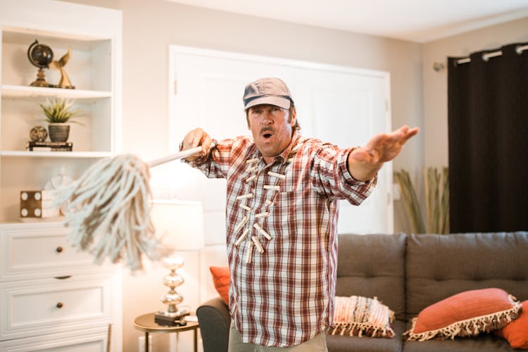 Person In Checkered Shirt Holding A Mop