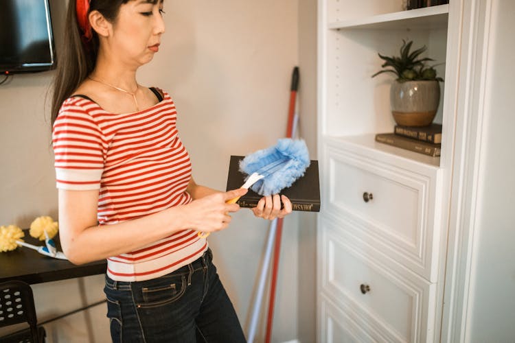 Woman Dusting A Book