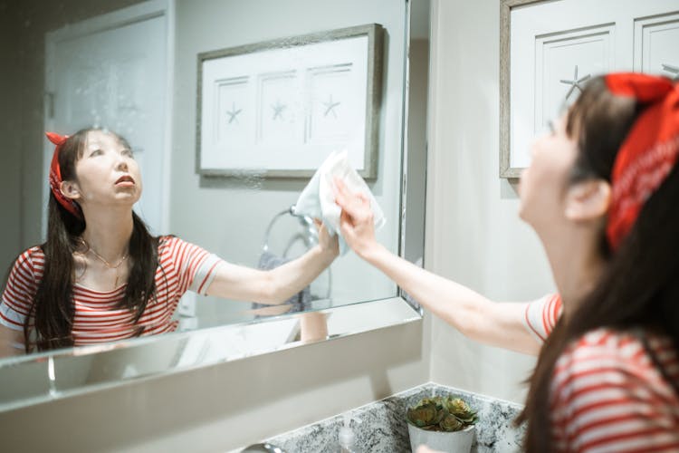 Woman Cleaning A Mirror