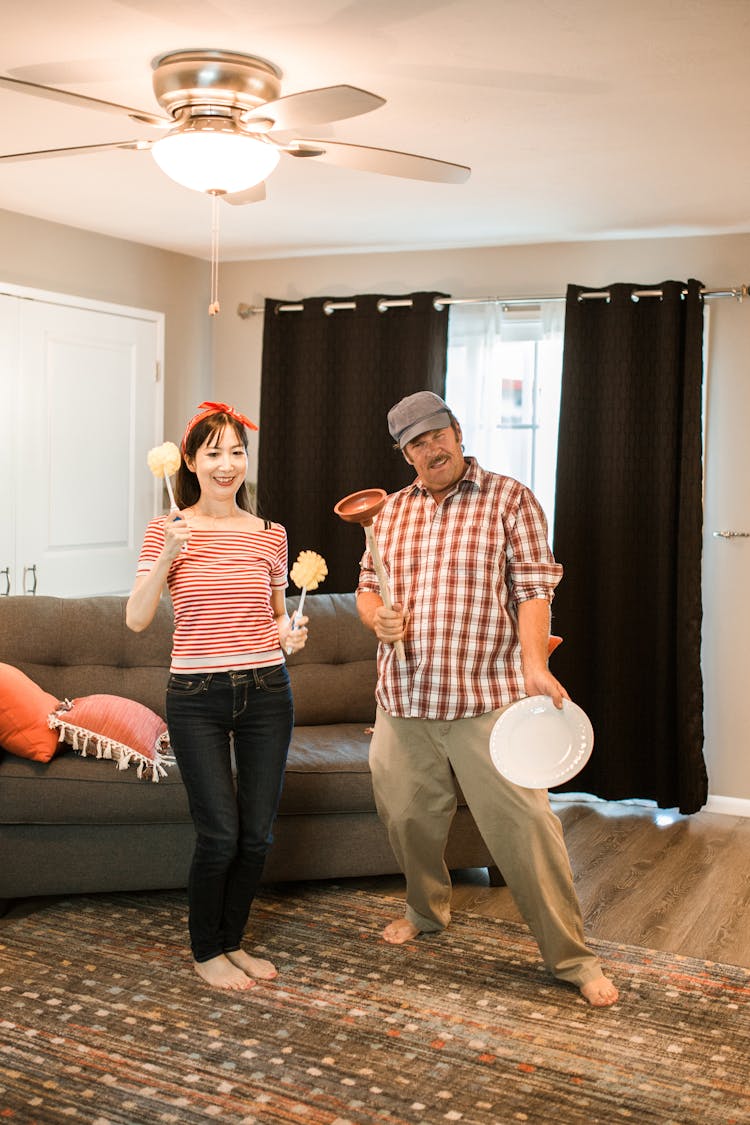 Couple Cleaning In A Living Room