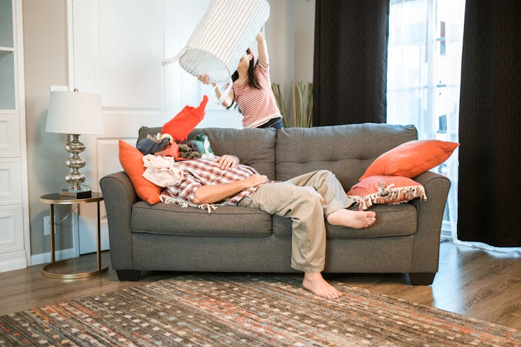 Couple Cleaning In A Living Room 