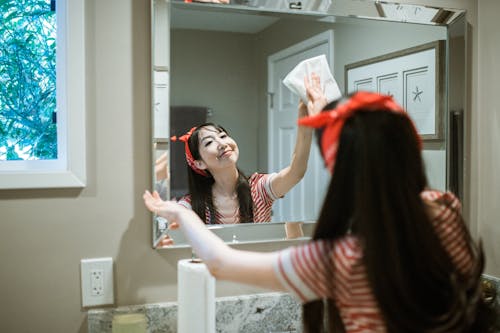 Free Woman Wiping the Mirror Stock Photo