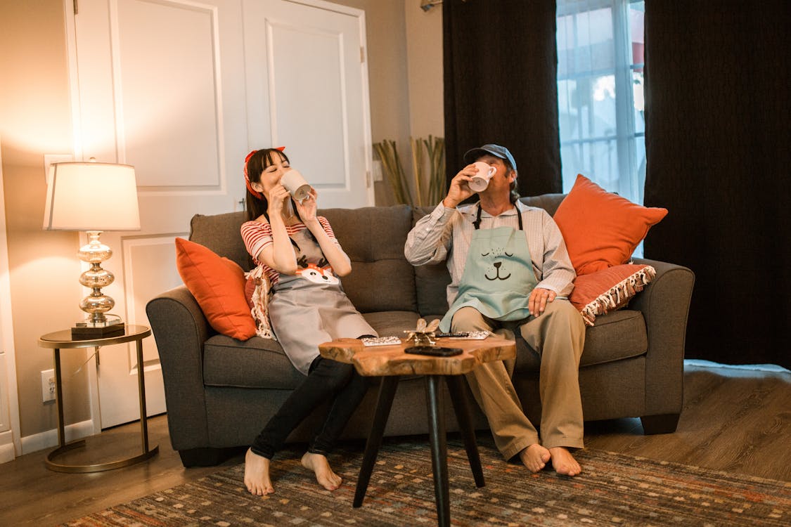 A Couple Drinking while Sitting on a Couch