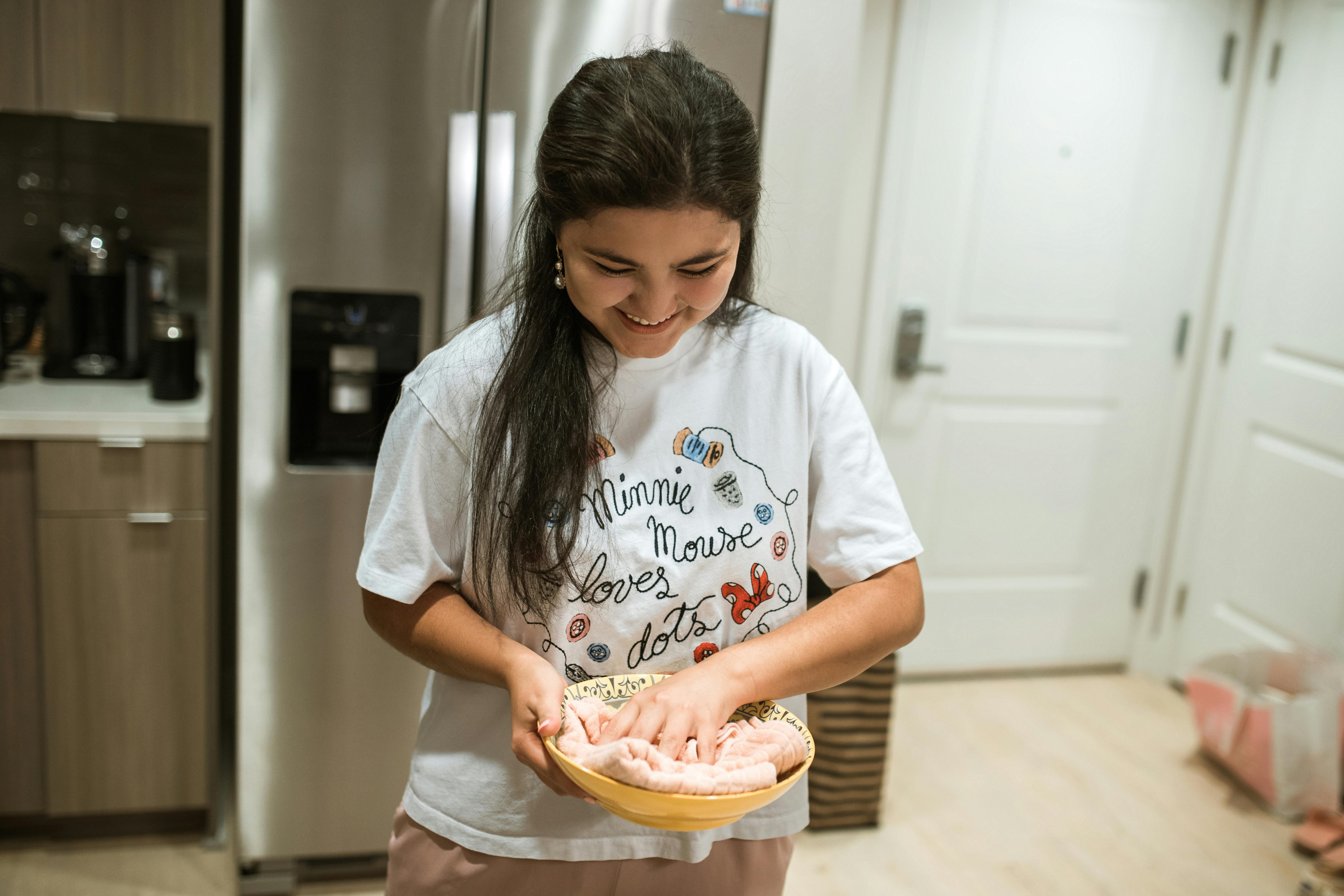 woman in white crew neck t shirt holding brown wooden tray