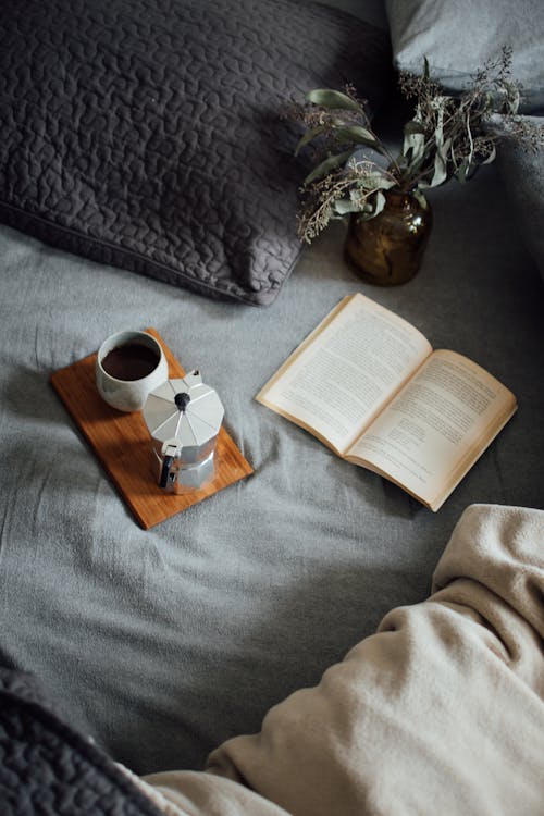 Free Coffee with book on cozy bed Stock Photo