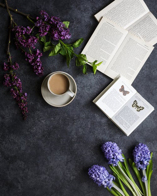 Чашка кофе возле цветов и книги