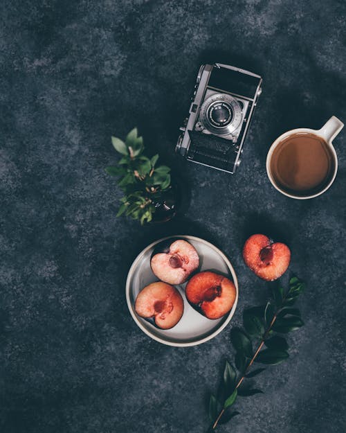 Photo Of Sliced Peaches Beside Analog Camera