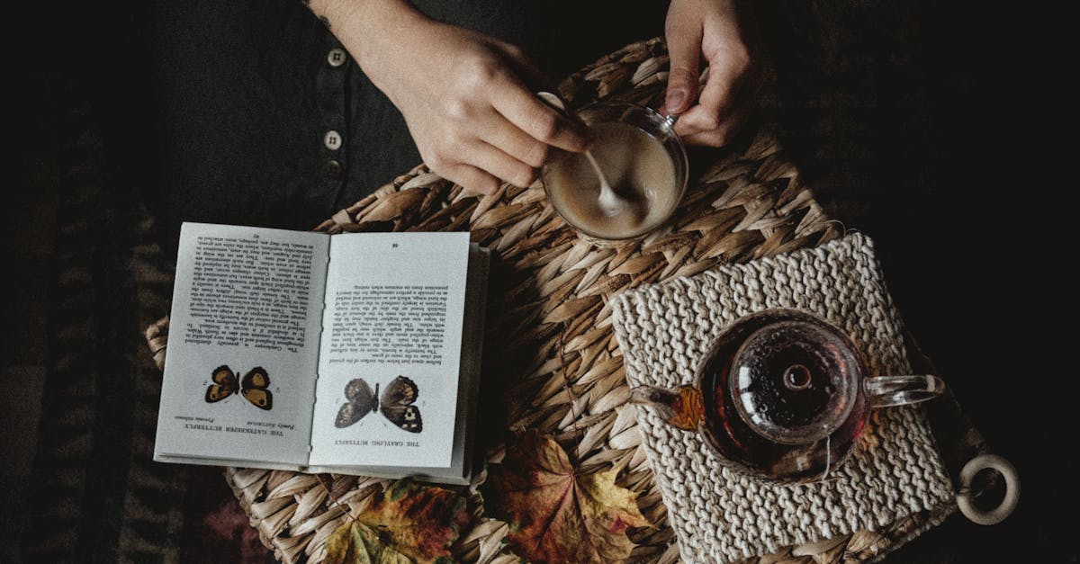 Person stirring Coffee beside Open Book · Free Stock Photo