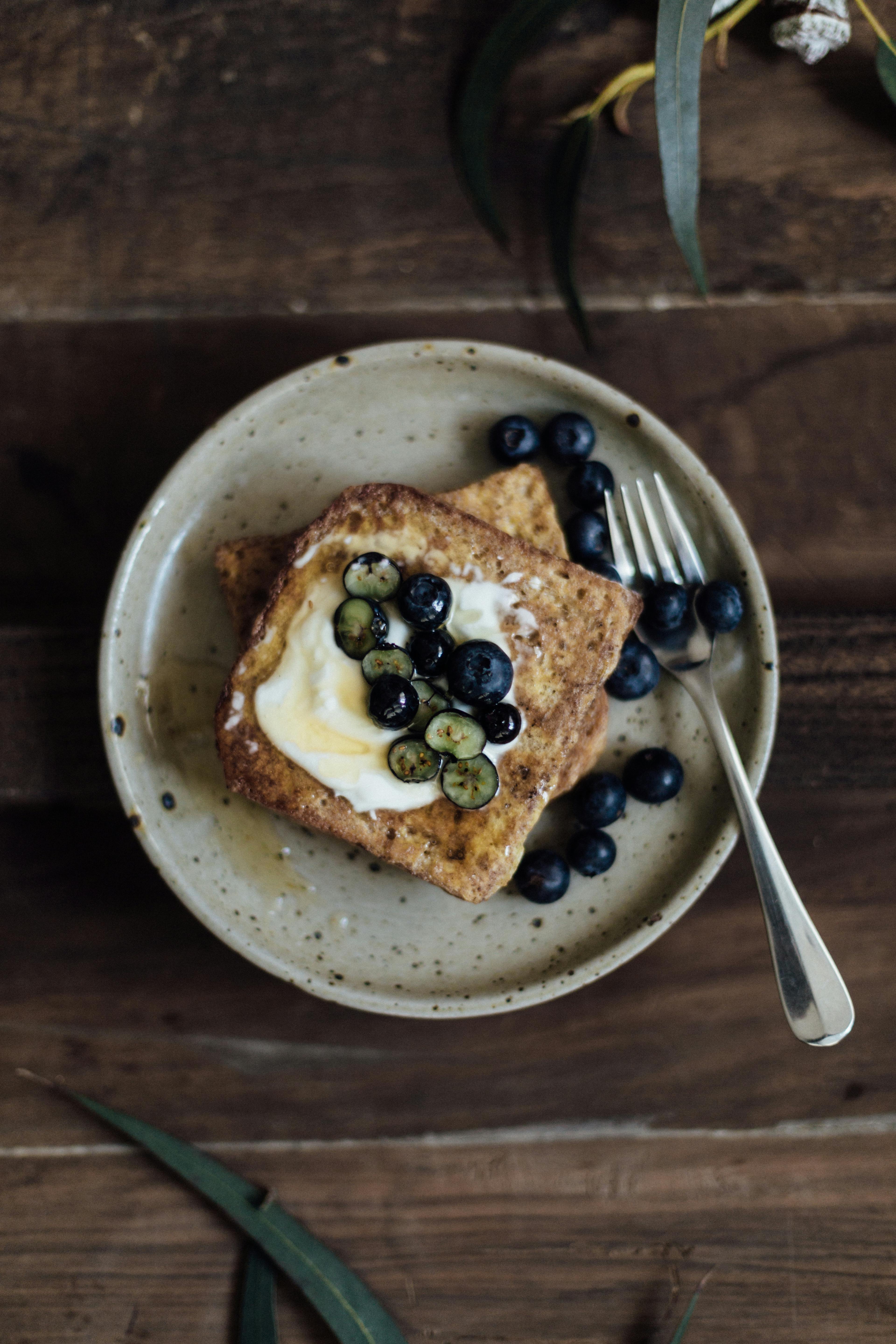 delicious breakfast with toasts and berries on table