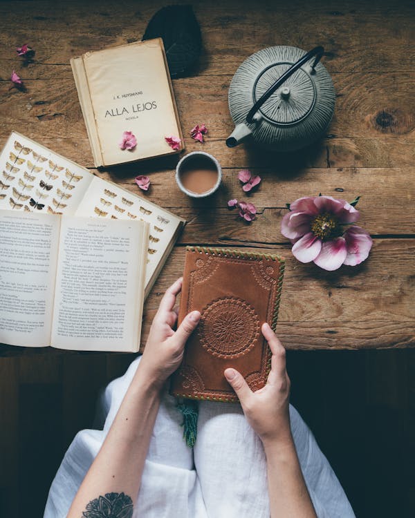 Free Crop woman with leather notebook near table Stock Photo