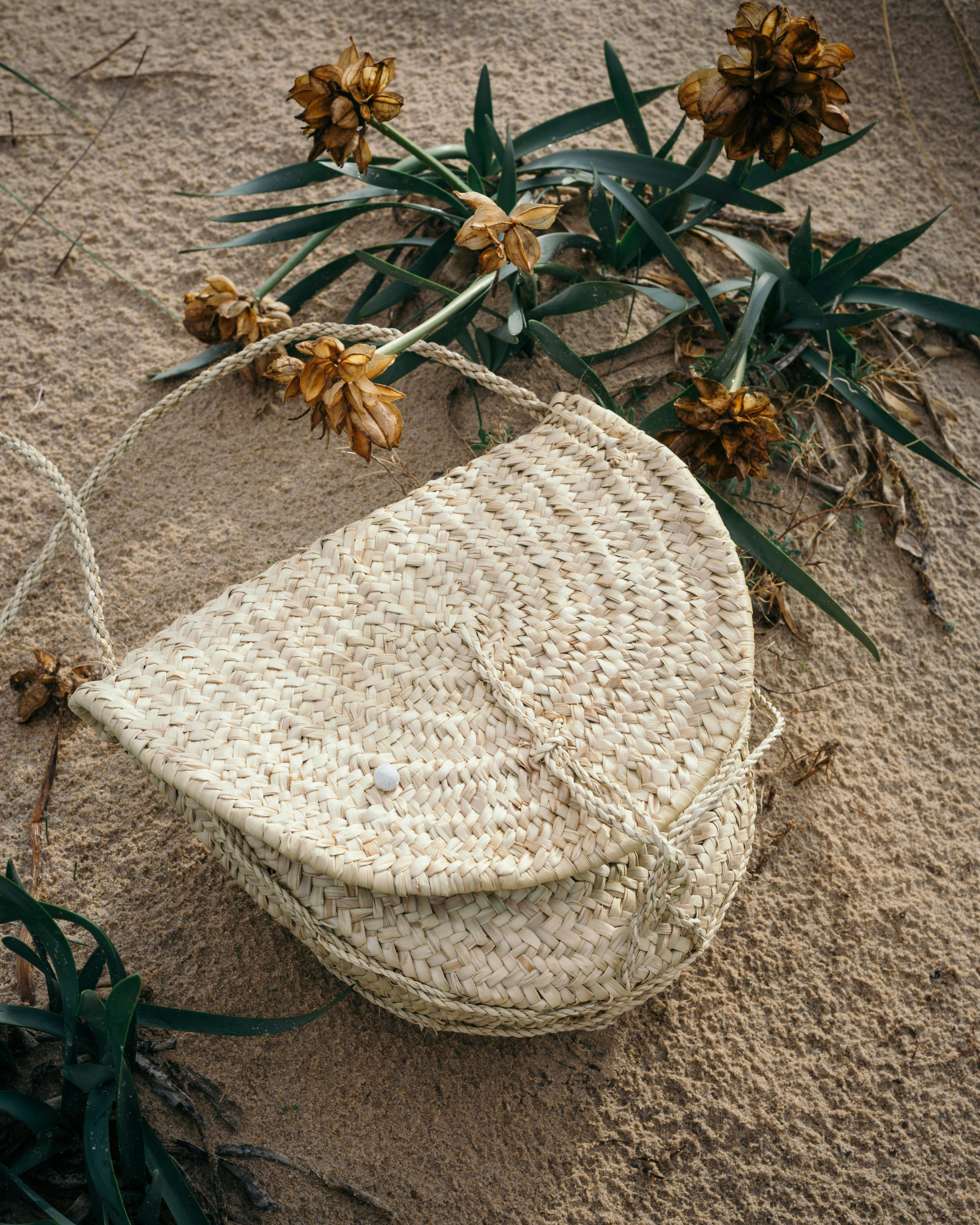 wicker handbag placed on sand