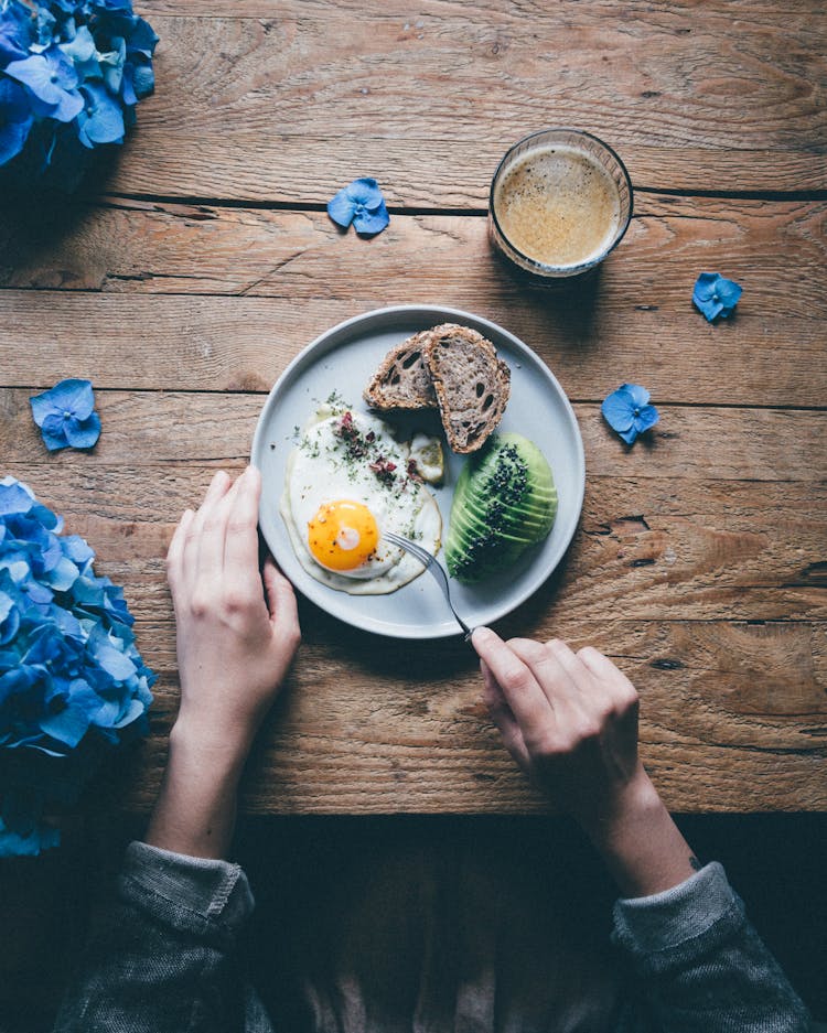 Crop Person Eating Fried Egg