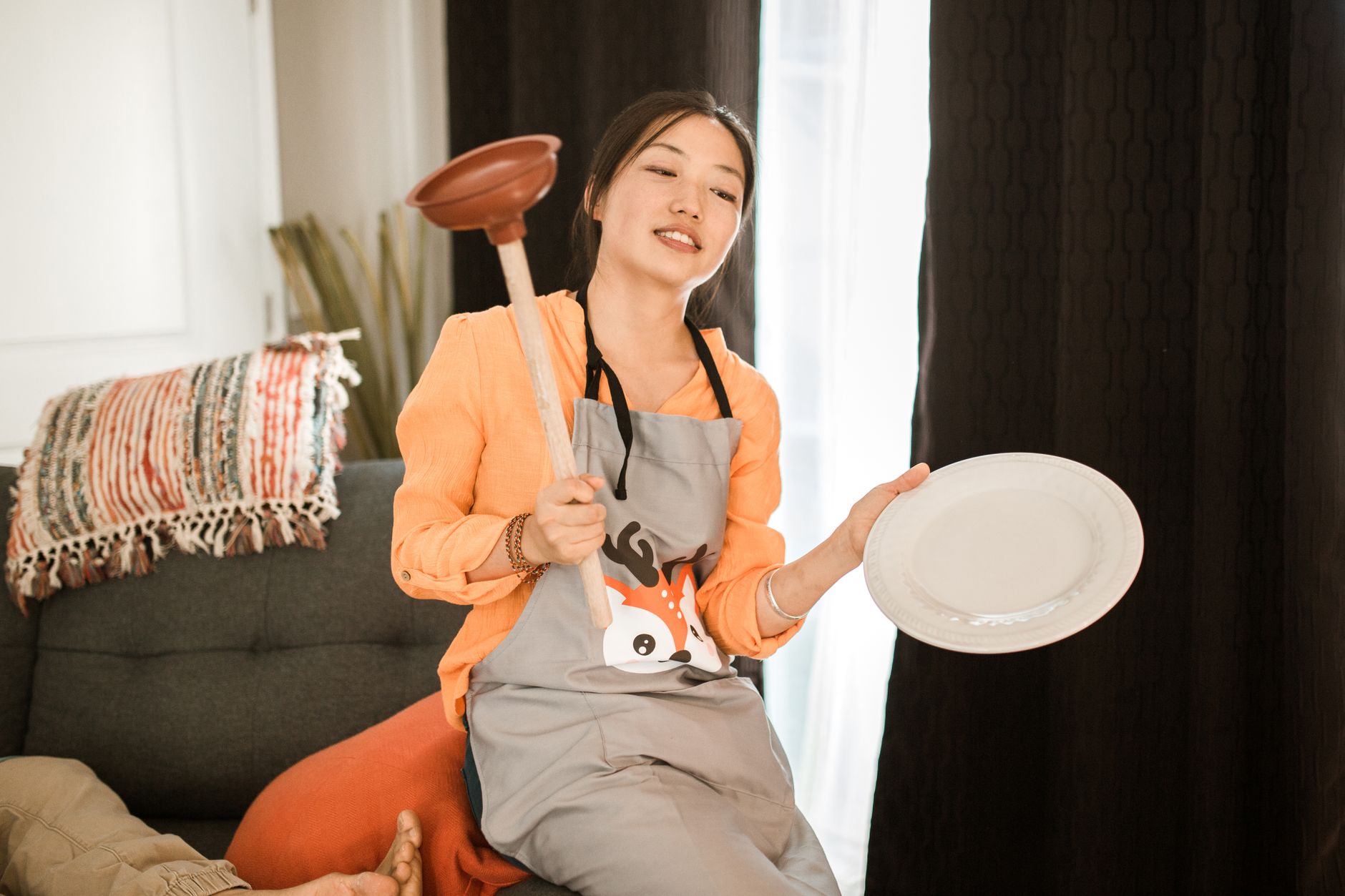 Plunger being used to clear a kitchen sink drain